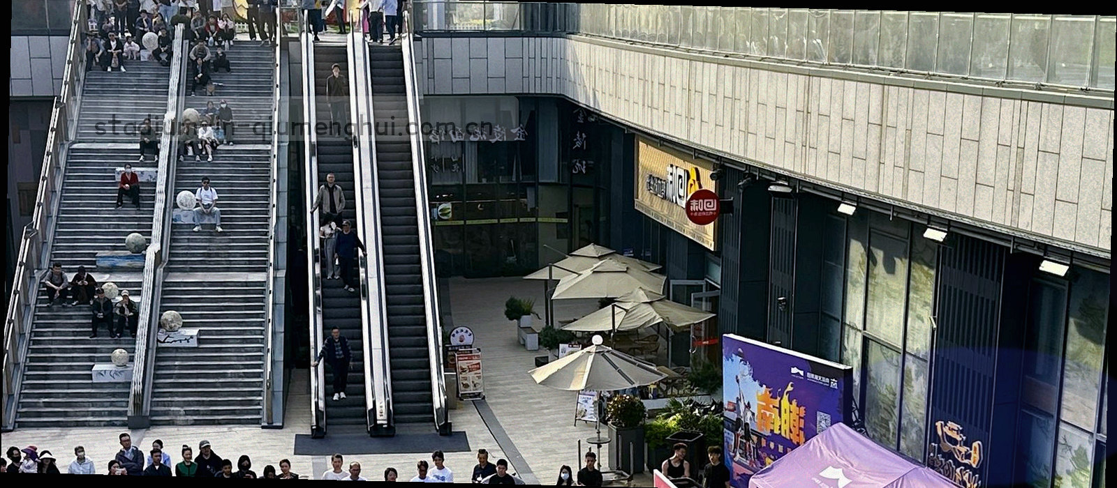夜间球场俯拍，灯光带横贯看台与草皮